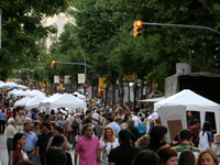 Carrer ple de gent i paradetes, a la Fira d'Entitats de Sants